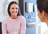 Smiling woman talking to dentist