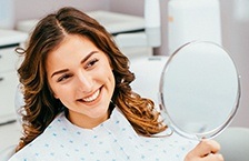 Woman looking at smile in mirror