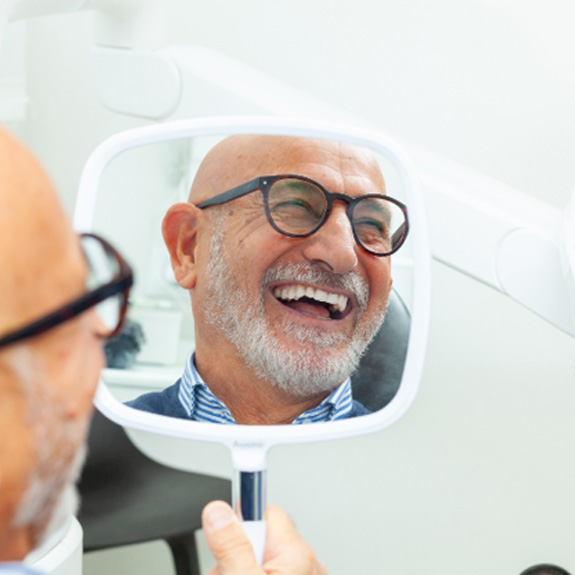 A man smiling at his new dentures