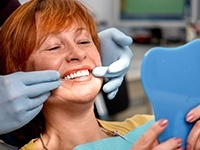 Senior woman looking at smile in mirror