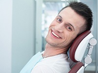 Man leaning back in dental chair and smiling