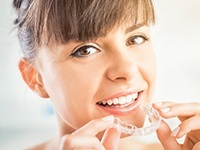 Woman placing Invisalign tray