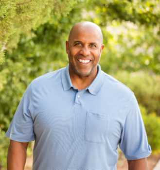 An older man standing outside smiling