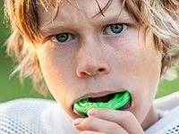 Teen boy placing athletic mouthguard