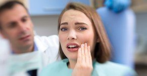 Woman holding cheek in pain