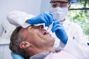 man sitting in dentist chair smiling