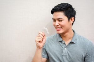 person holding their Invisalign aligners