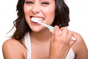 young attractive woman smiling brushing teeth