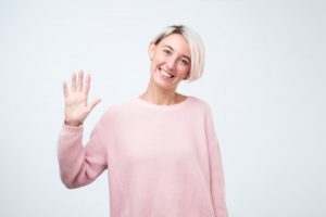 Smiling woman waves at her Midlothian dentist in COVID-19