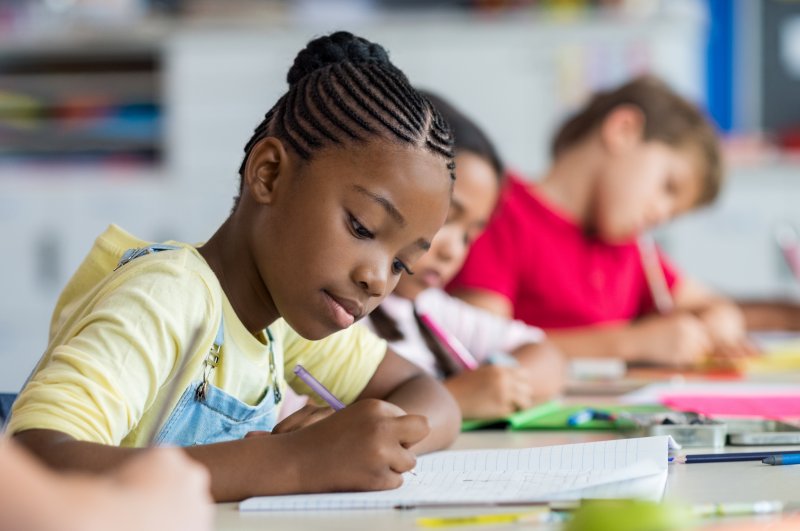 Closeup of girl taking a test in classroom