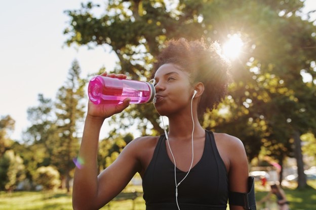 Woman drinking from her refillable water bottle.