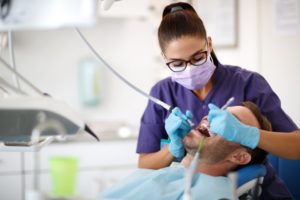a dental assistant helping a patient