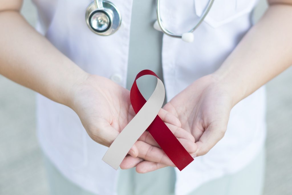 Dentist holding oral cancer ribbon during Oral Cancer Awareness Month