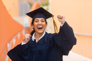 a student smiling while attending their graduation