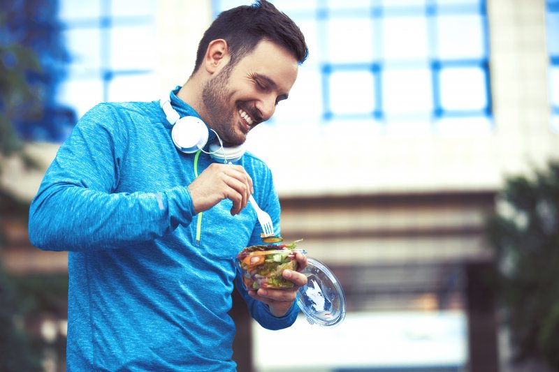 A man smiling with good dental health as he exercises in the new year